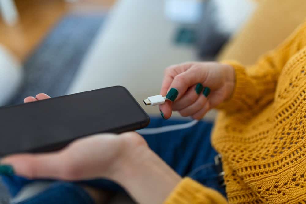 A woman plugging in her phone charger