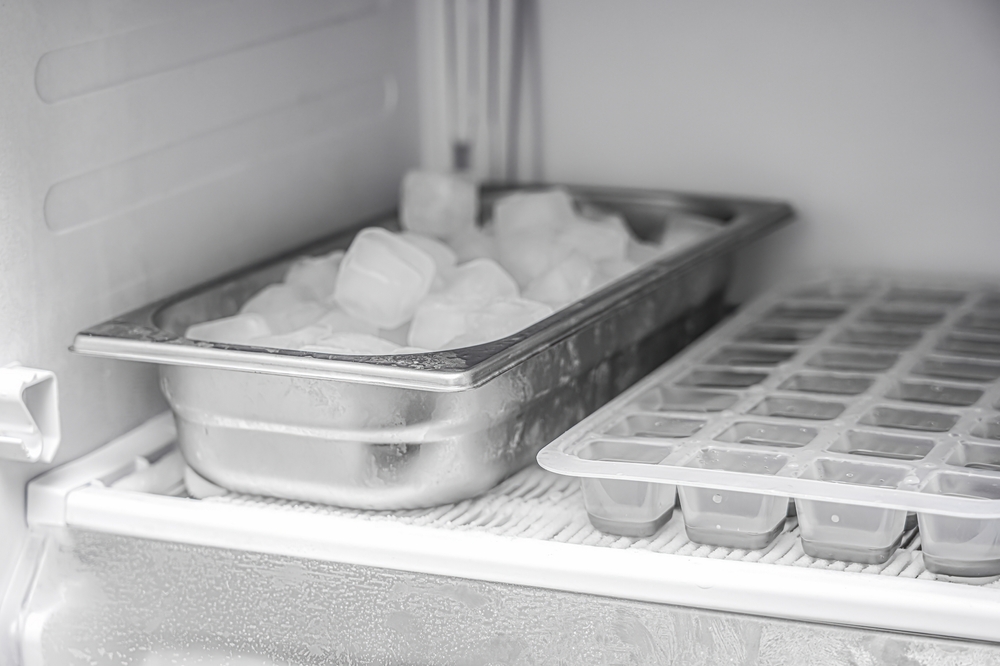 Frozen ice cubes in a stainless steel ice trays and ice cube trays
