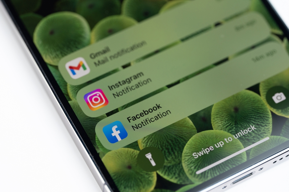 A locked iPhone home screen showing notifications from social media