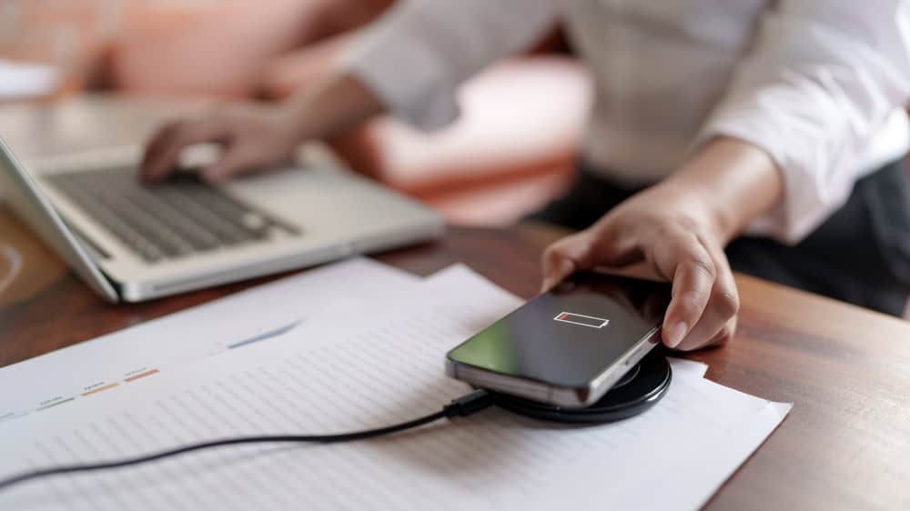 A woman charging her phone with a wireless fast charger on