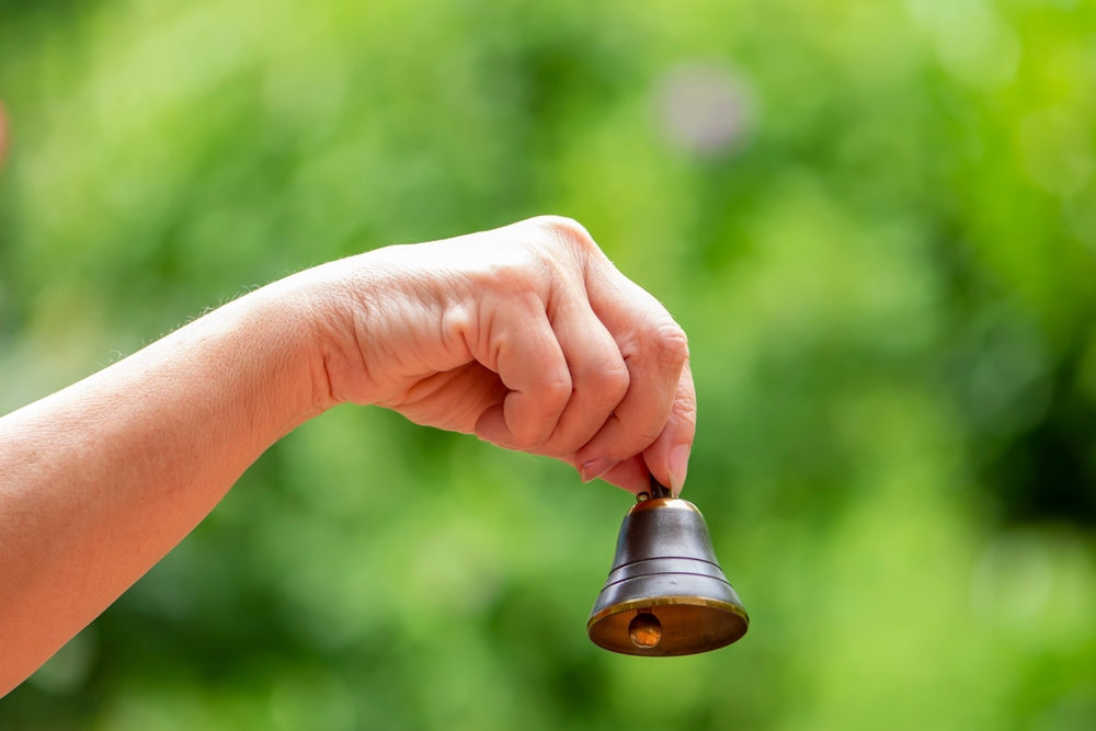 A hand ringing a school bell