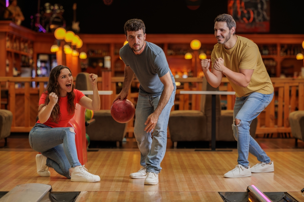 Competitive friends bowling in a bowling alley
