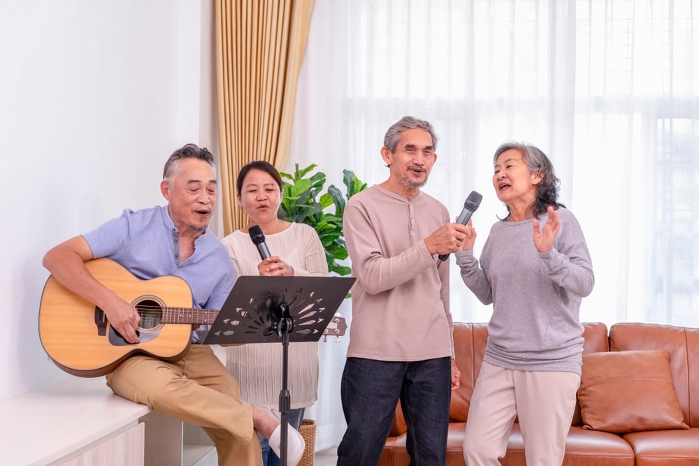 A group of Asian friends at Karaoke and making their own music by playing their own guitar and singing