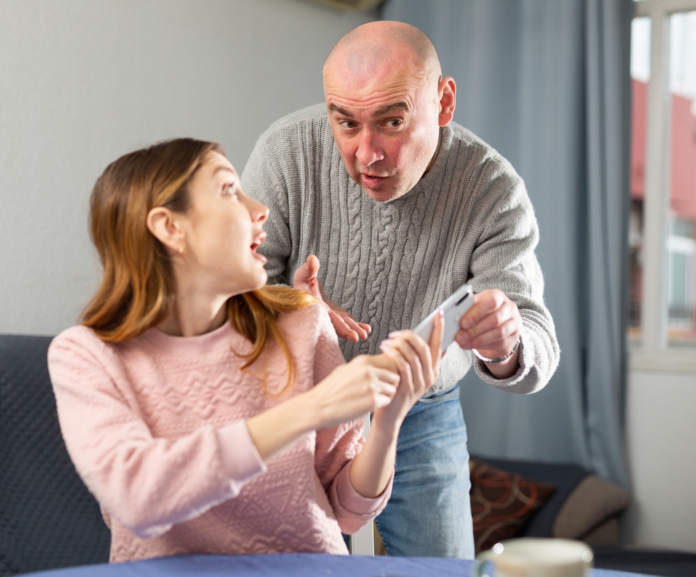 Ajealous older husband trying to take the phone from his younger wife and snoop