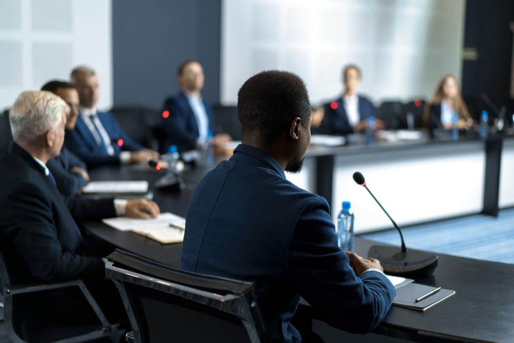 A group of politicians speak in a meeting