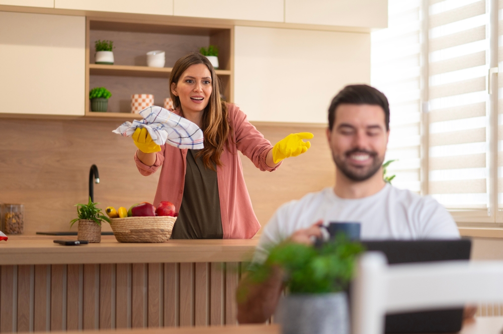 Woman angry and complains about having to do household chores alone, the man ignores and continues to press phone