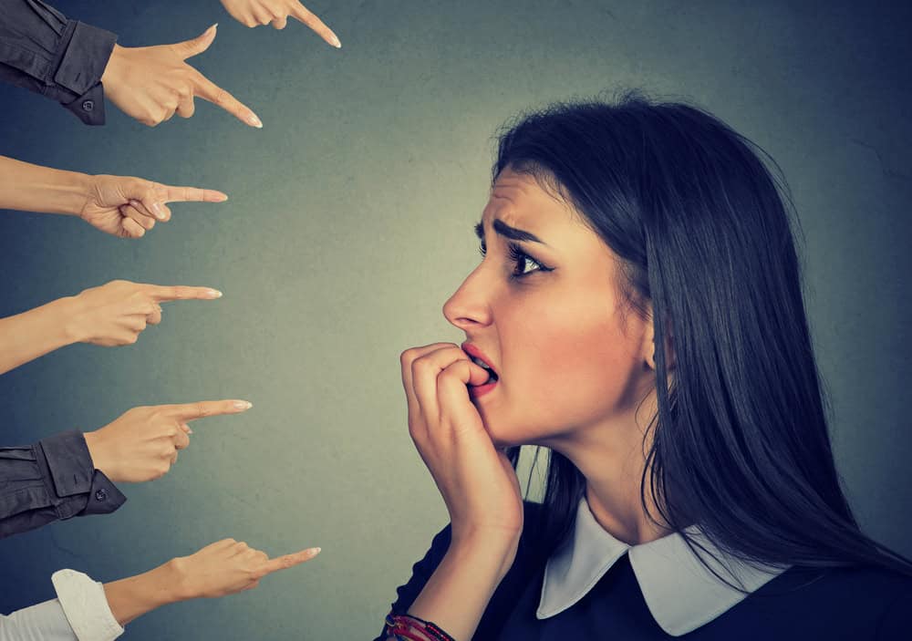 An anxious young woman being judges by others