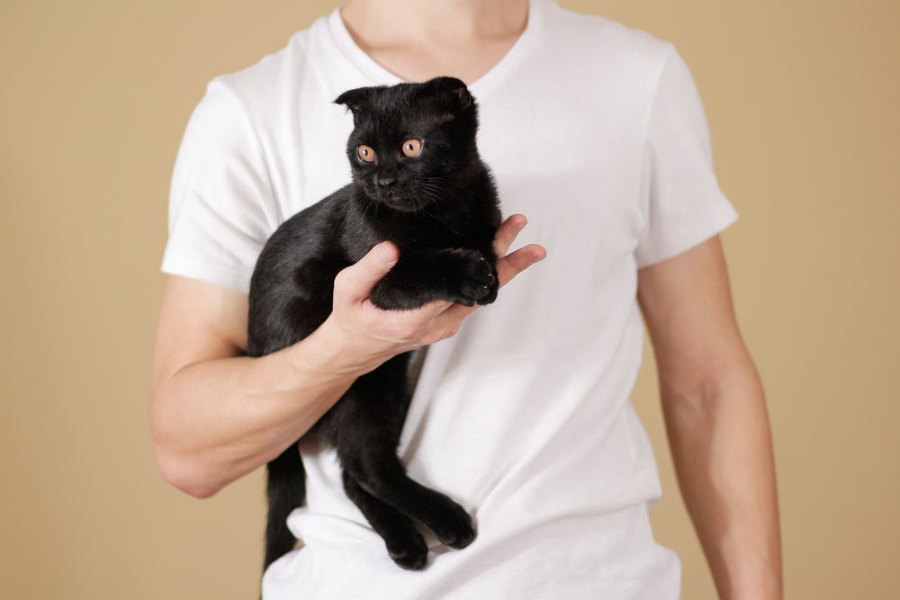 Man holding a black cat