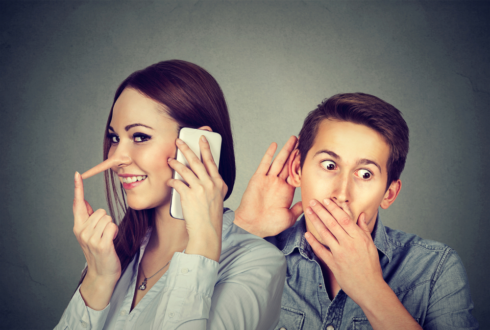 A woman having a conversation on phone and she is lying which is depicted by her elongated nose, a man listens in to the conversation and is shocked by her lies