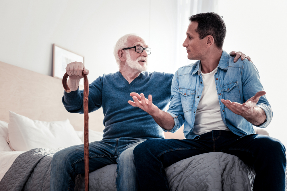An elderly senior father having a friendly conversation with his adult son