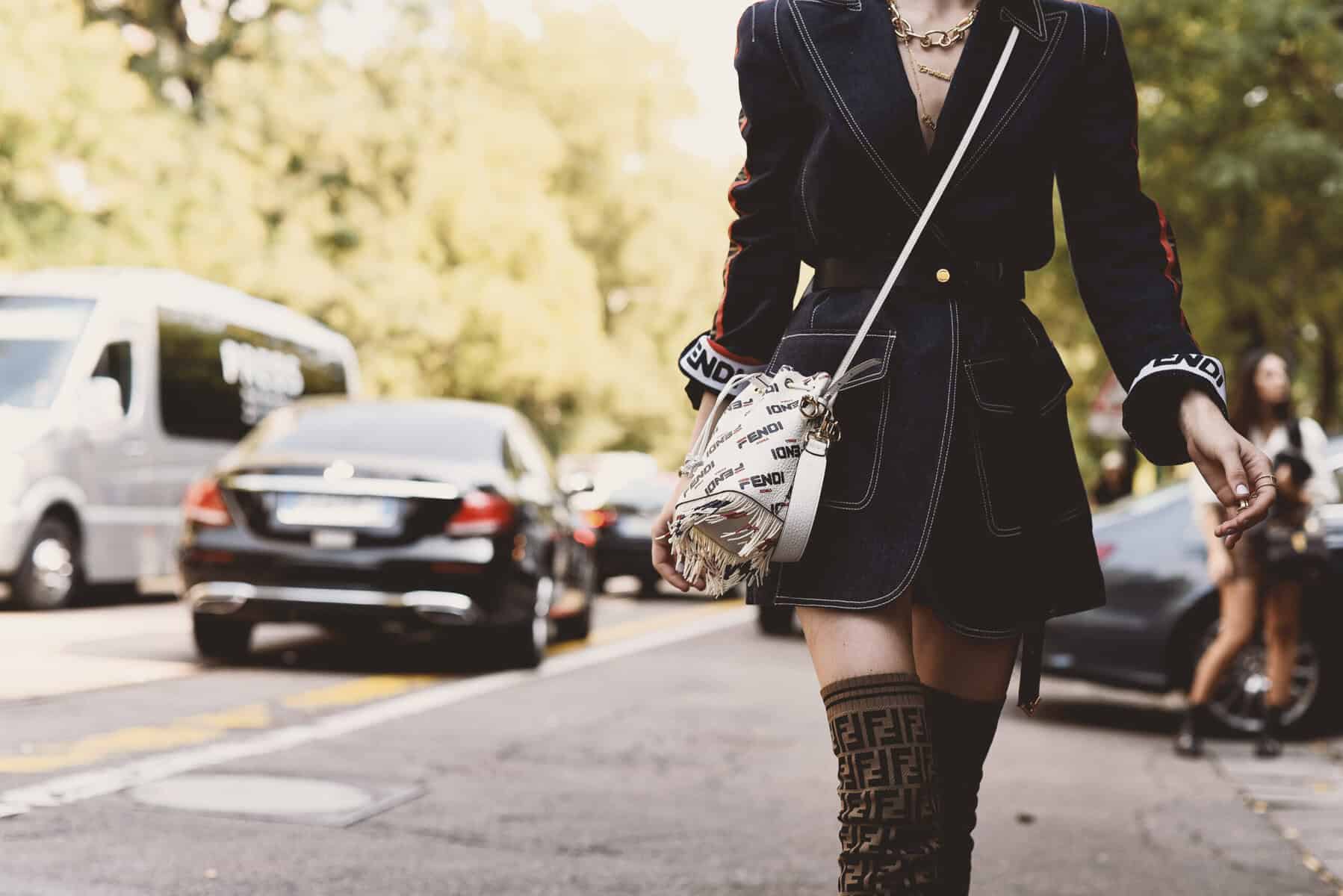 Woman walking on a city street wearing Fendi clothing.