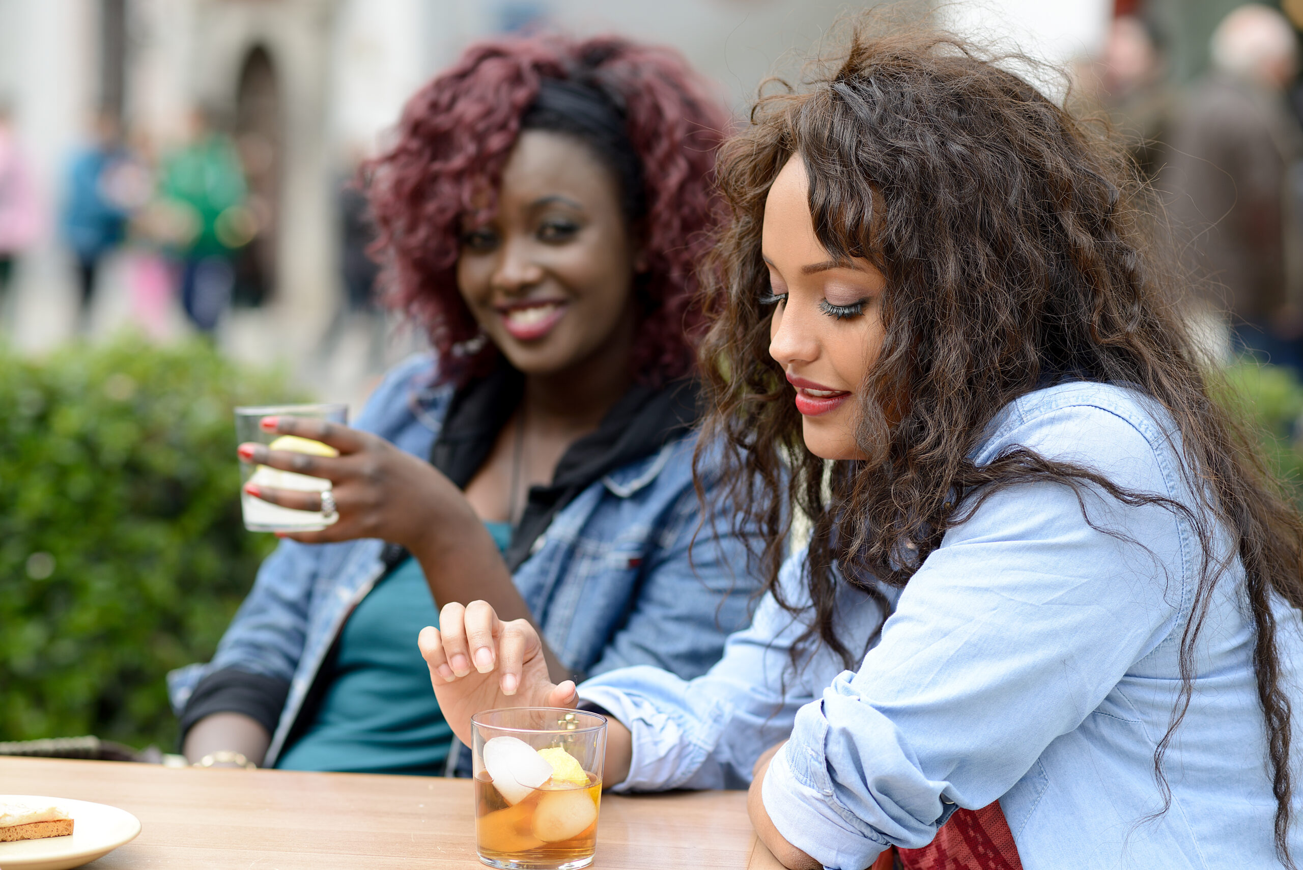 Two friends having a drink with one of them uninterested in the conversation.