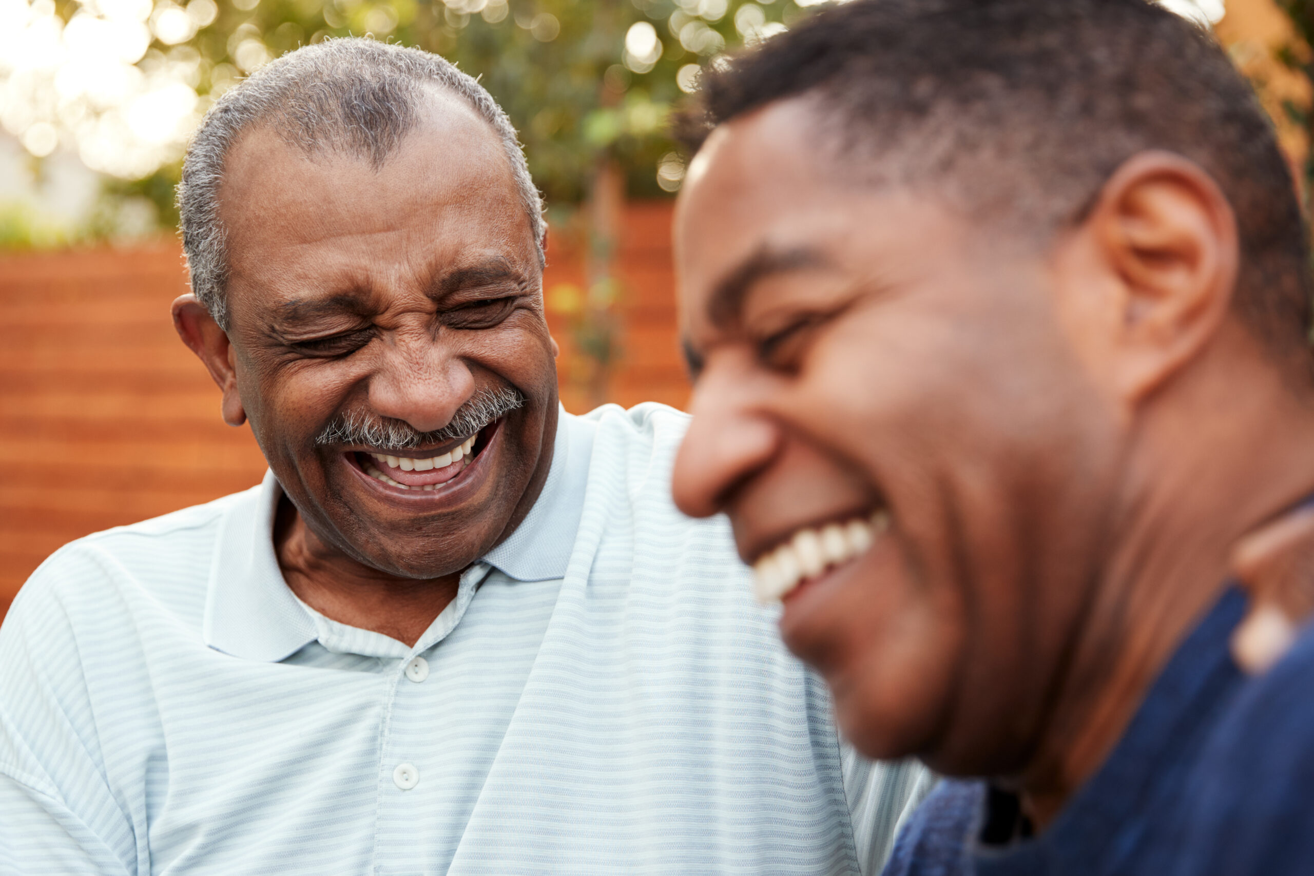 An adult man having a laugh with his aging father.
