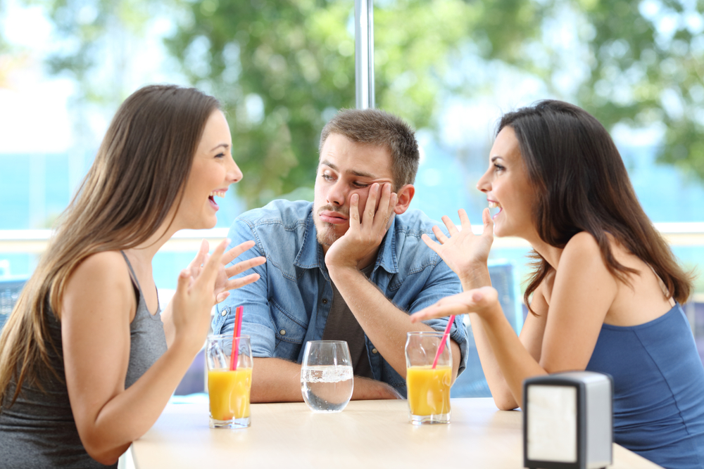 A bored man listening to his two female friends talking about the details of their lives. 