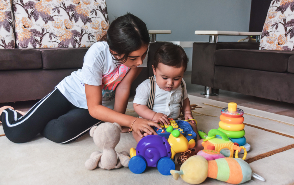 An elder sister playing games with her younger brother