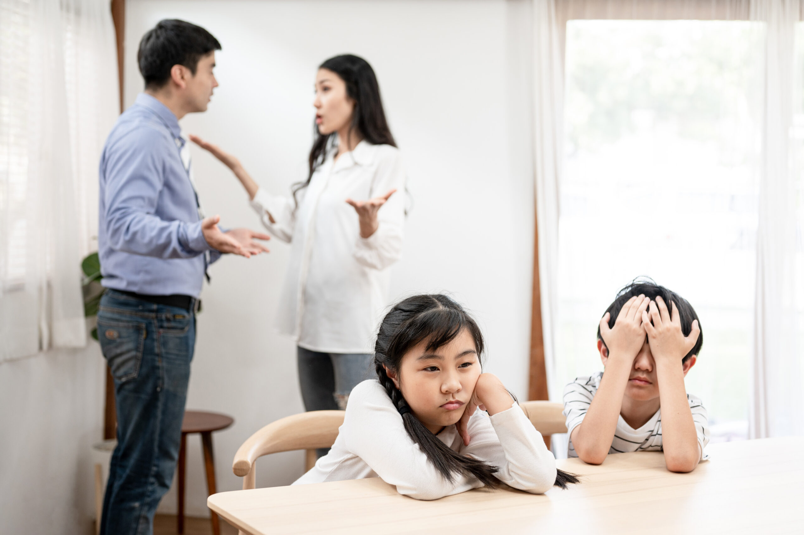 Stressed and sad children with toxic arguing parents.