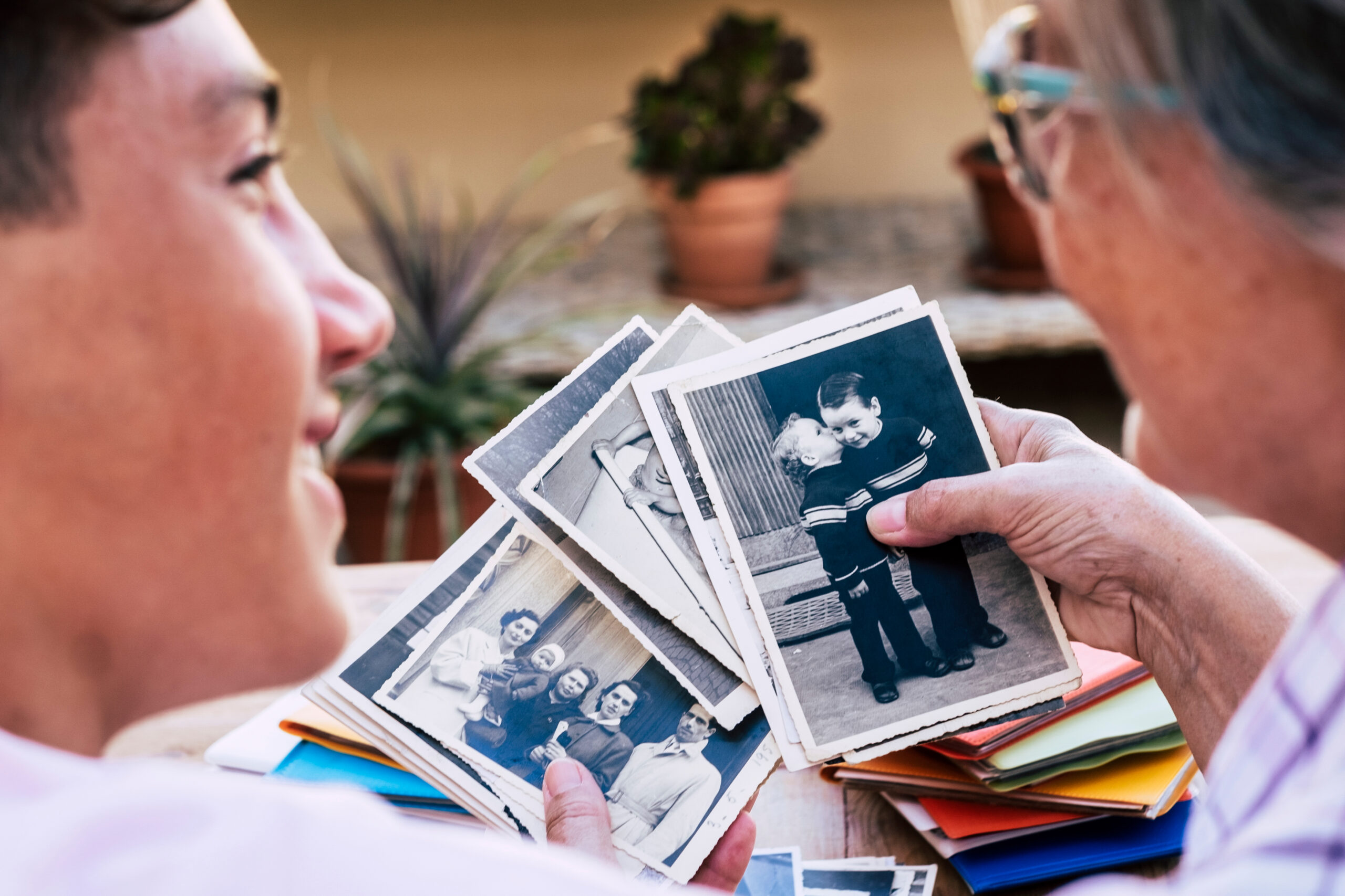 A mature woman telling stories to her grandson while looking through old photographs.