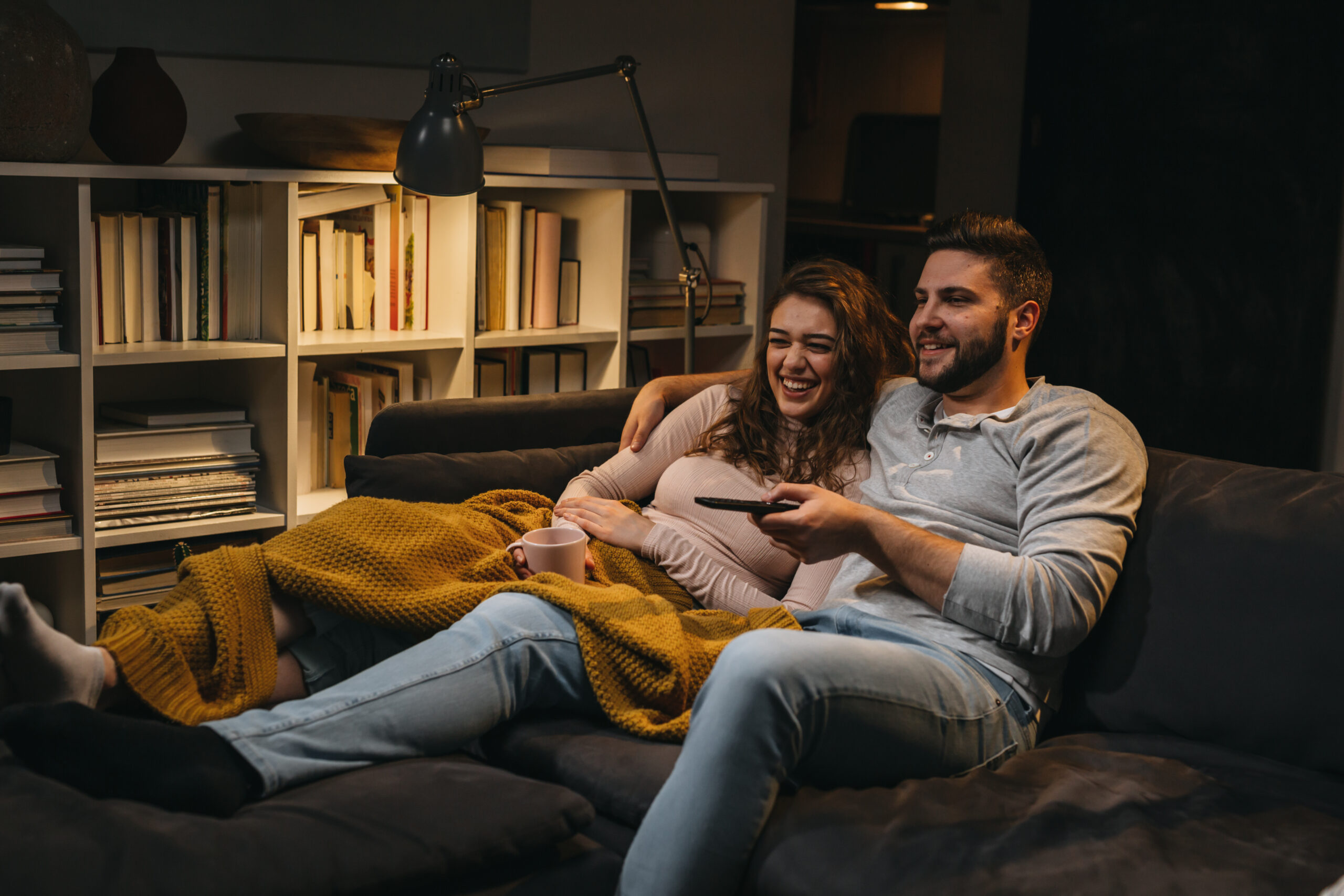 A couple watching TV together at home.