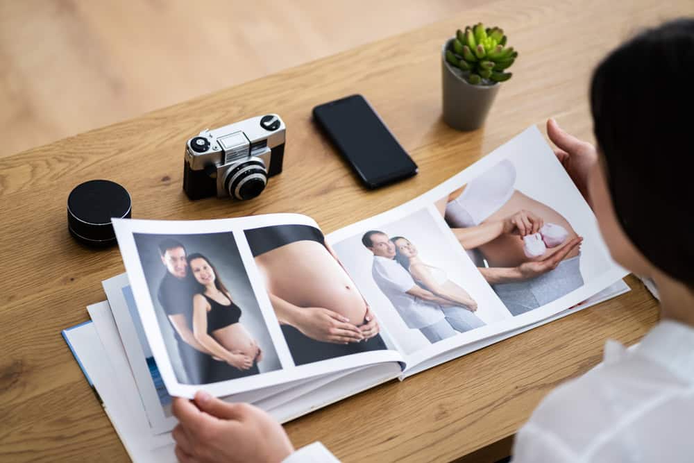 A woman looking at family photos and pictures from a pregnancy photoshoot