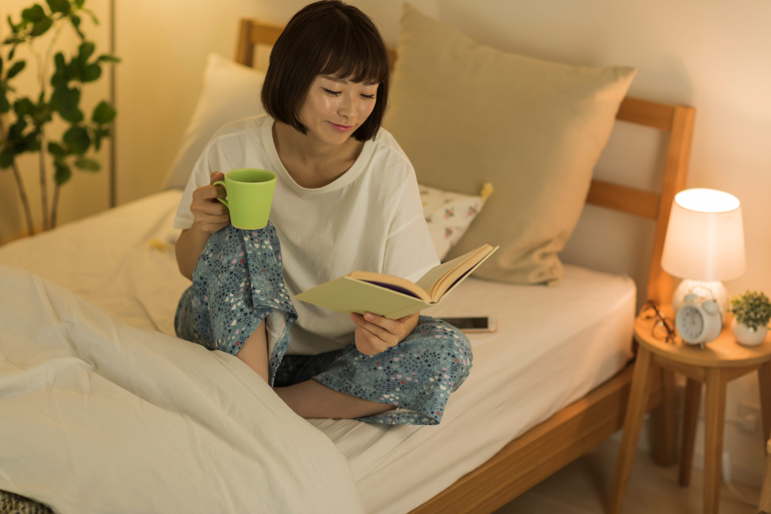 Woman spending time alone reading and having a cup of tea.