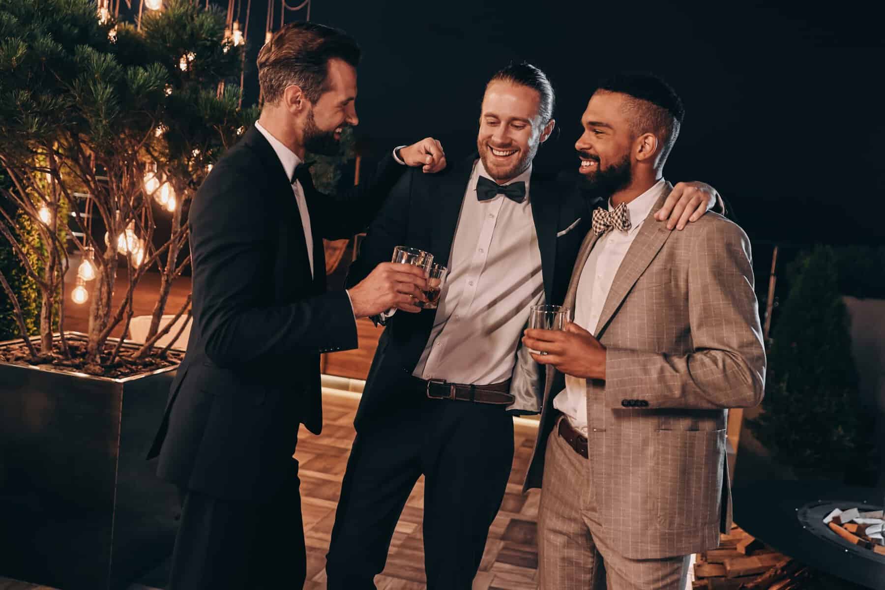 Three men at a wedding making crass jokes while drinking whiskey.