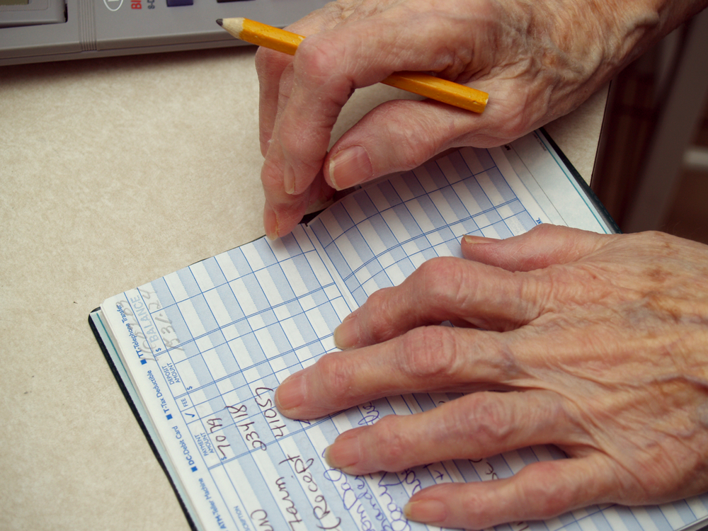 A senior using a checkbook