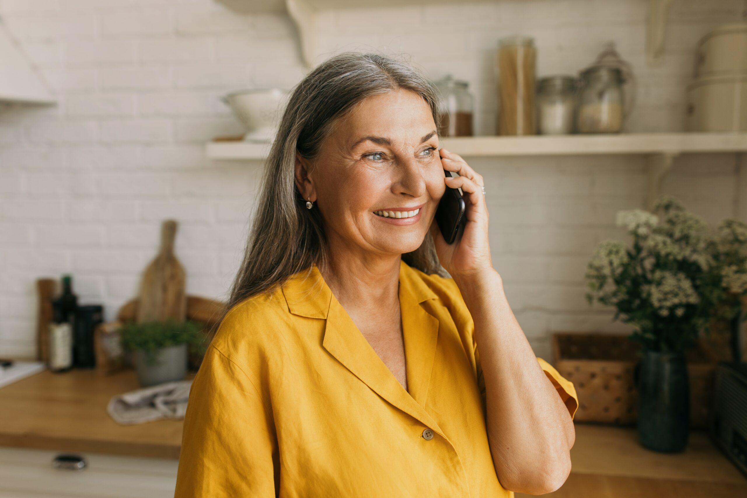 A mature woman taking a phone call from one of her children.