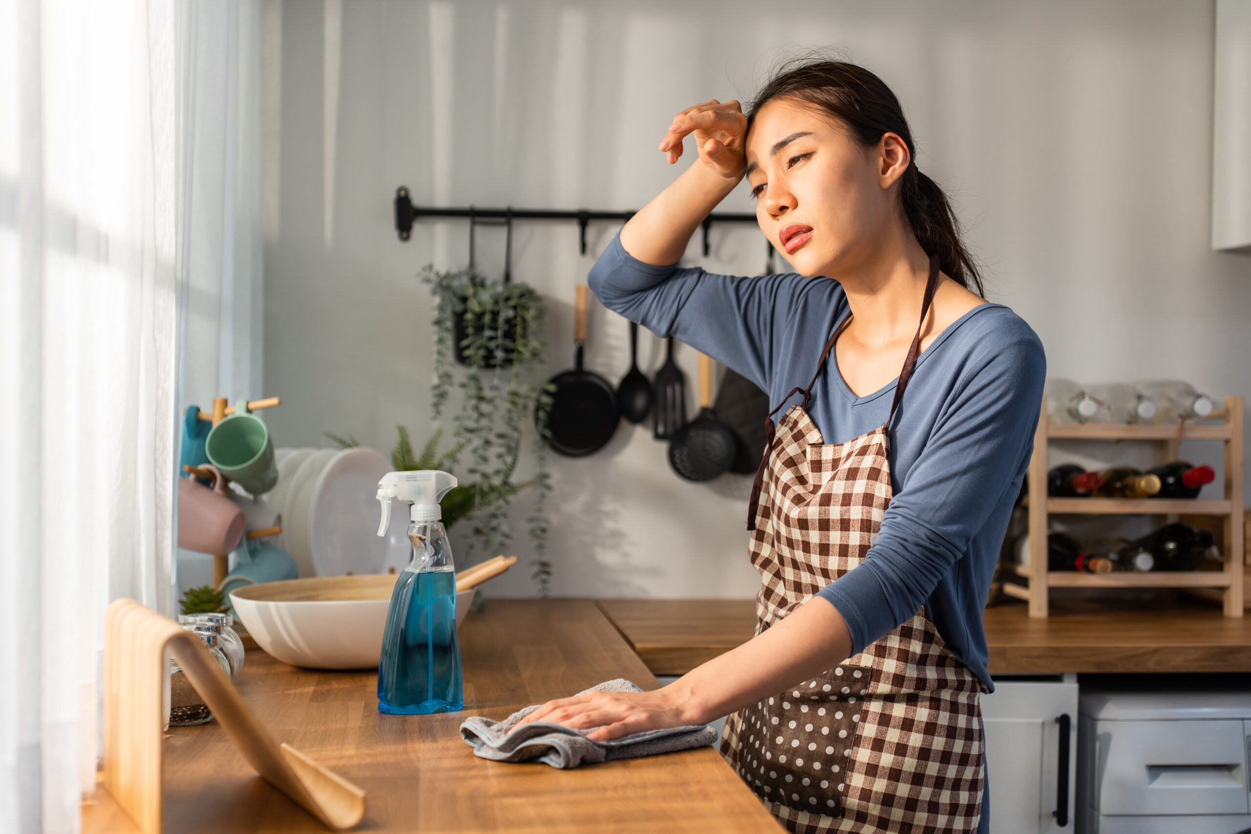 A woman who refuses to hire a house cleaner feeling exhausted.
