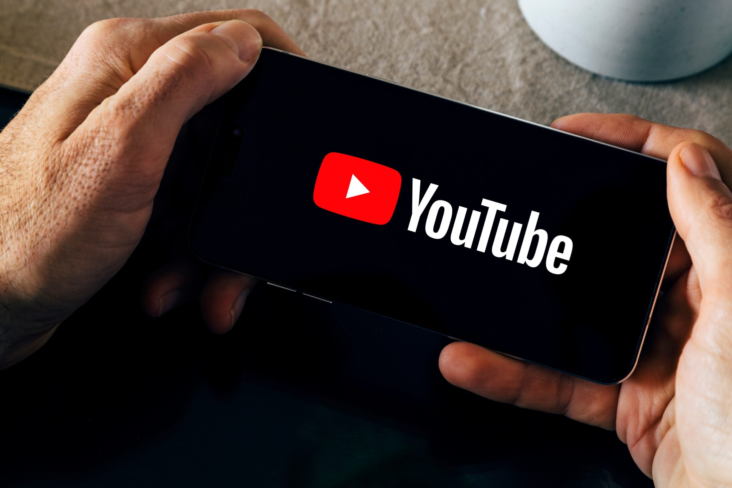 A man launching the YouTube app on his phone.