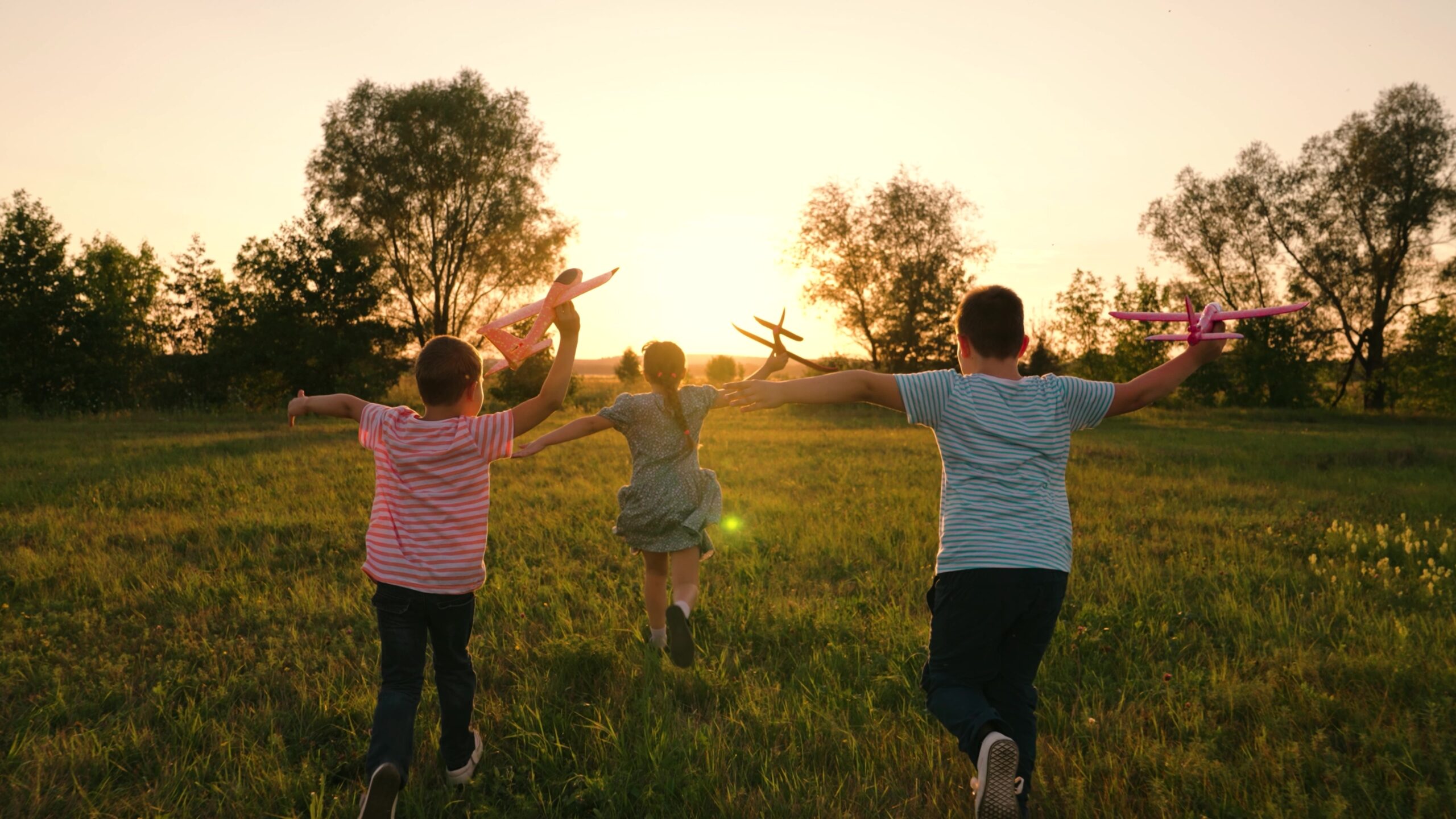 Happy children running through a field.