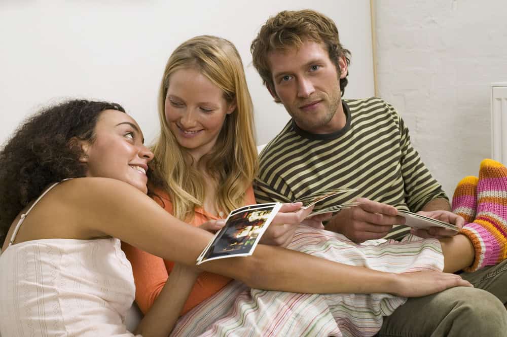 Three young people looking at pictures