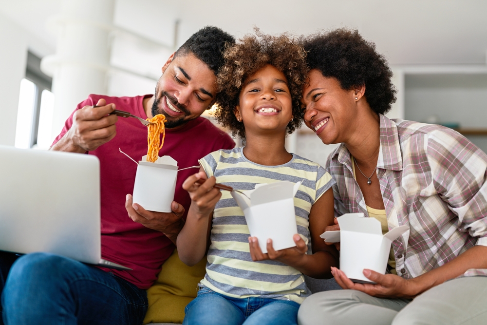 A family enjoying takeout food at home.