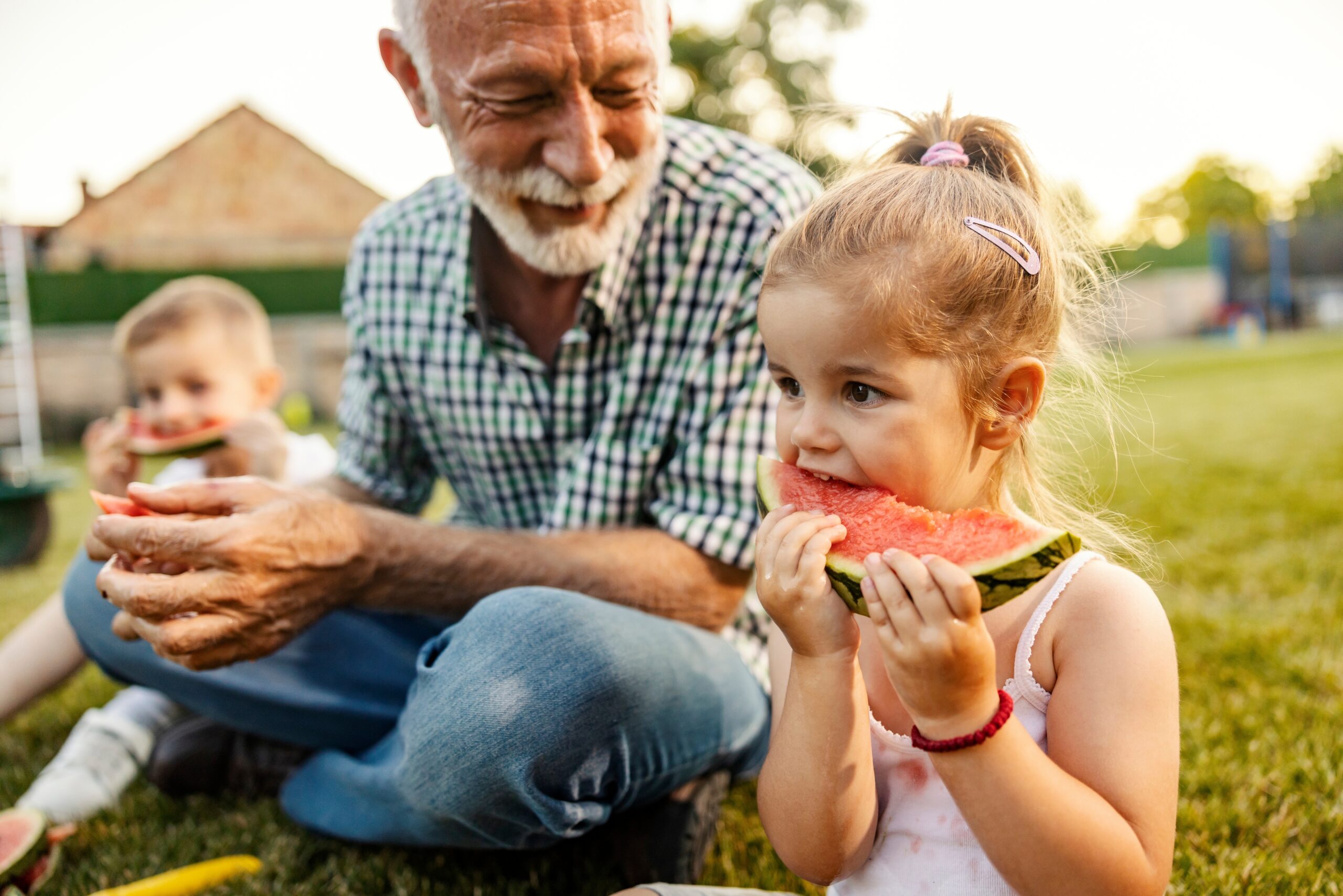 A joyful grandfather having an outdoor picnic with his grandchildren.