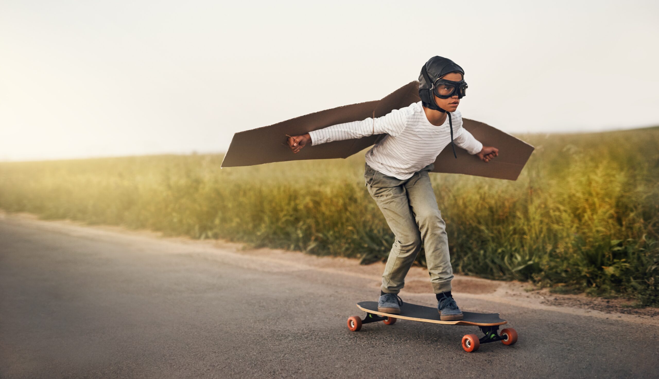 Boy riding a skateboard with wings.
