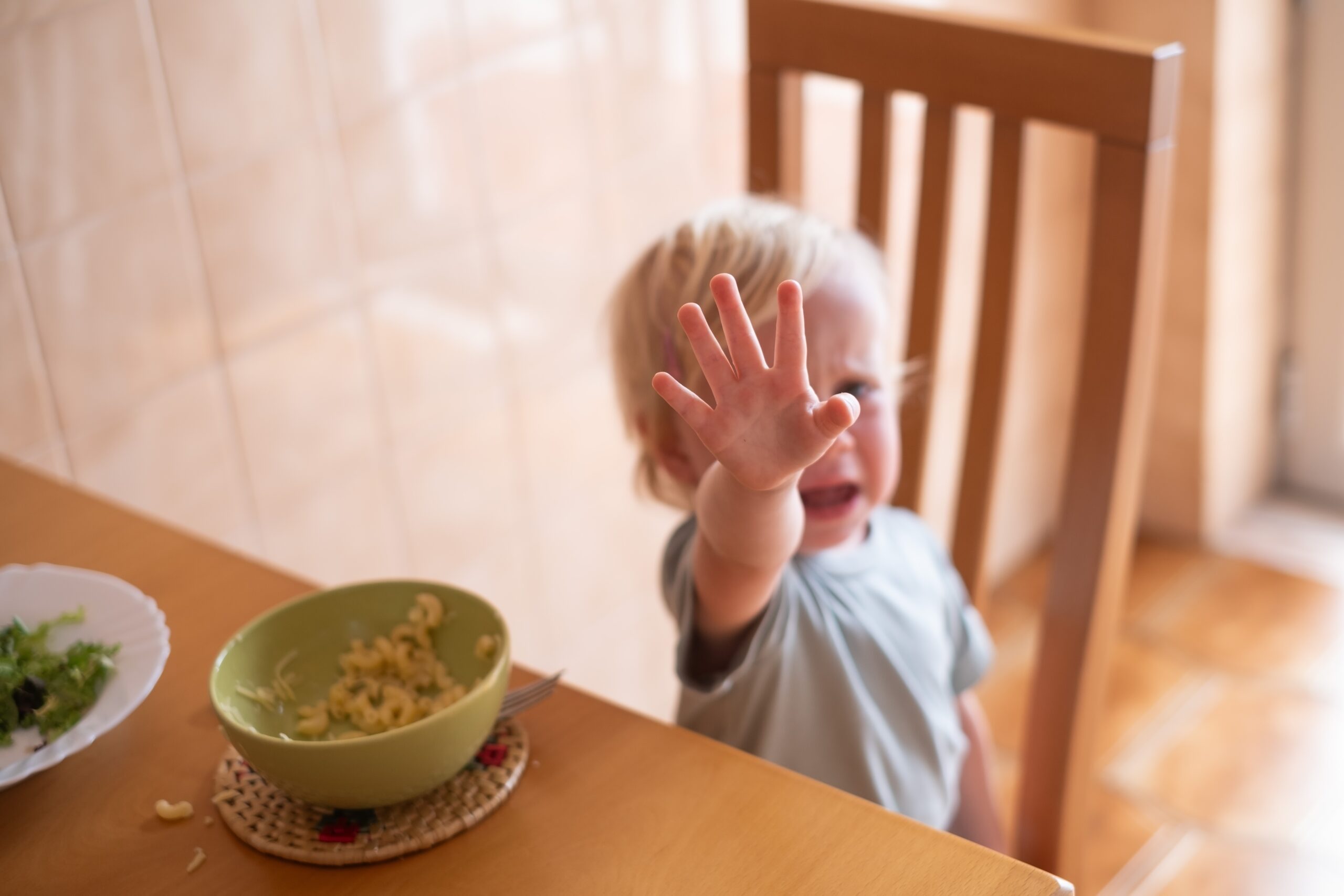 A toddler boy having a meltdown at lunchtime.