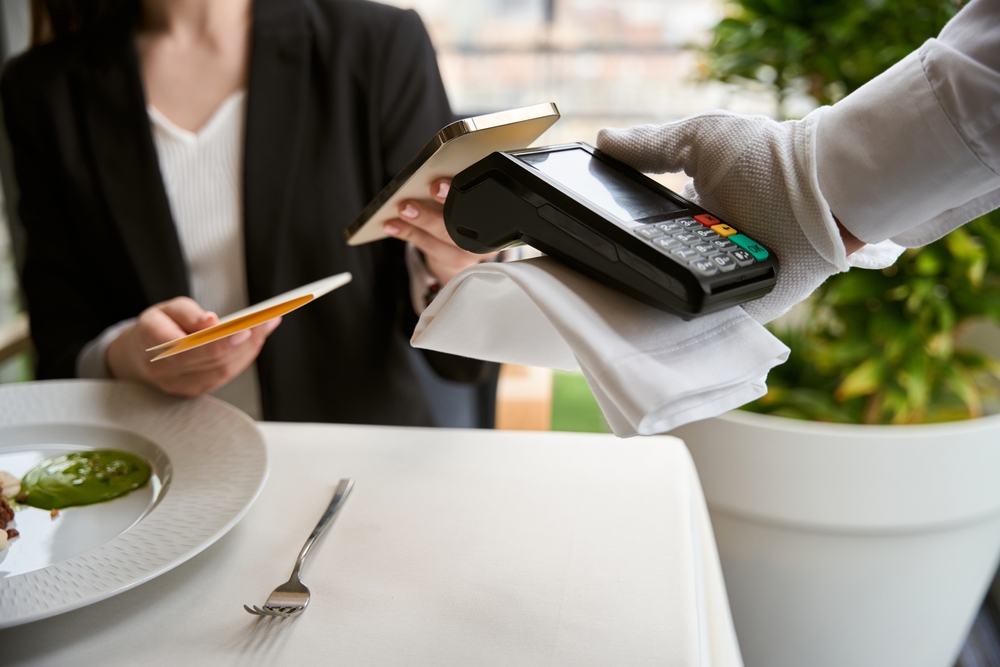 A young woman paying the restaurant bill