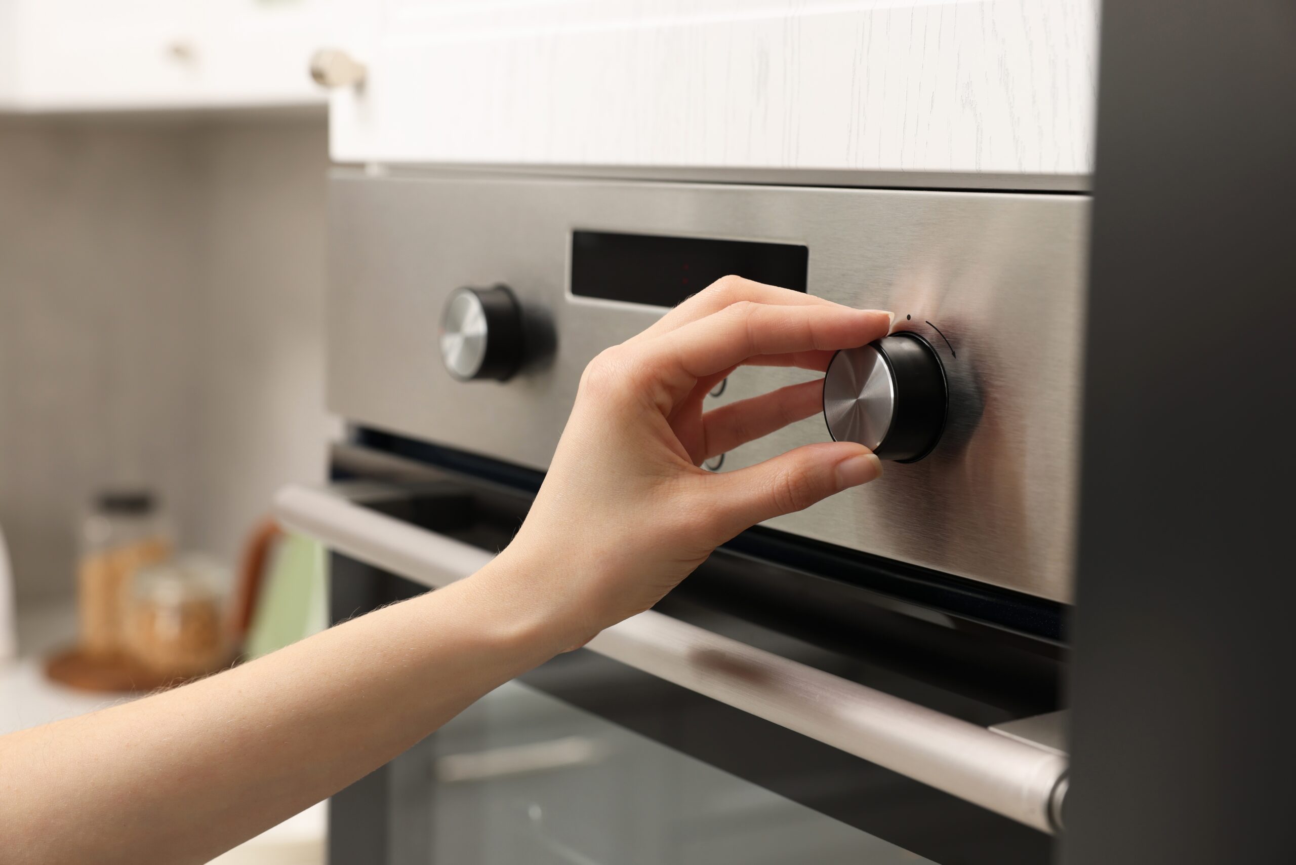 Woman checking to be sure her stove is off before she leaves the house.