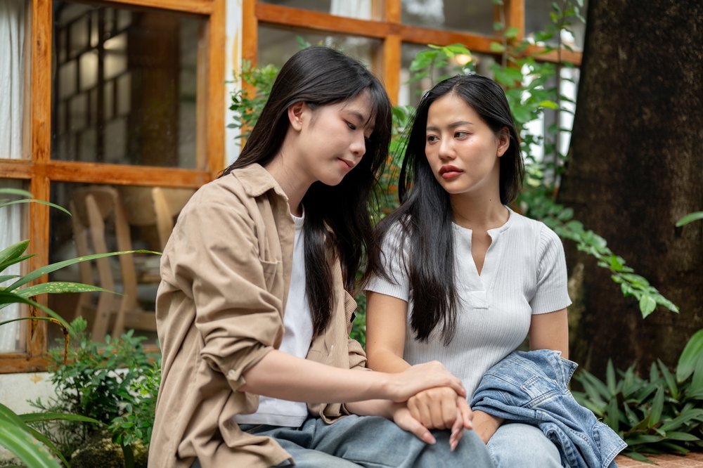A young woman comforting her friend