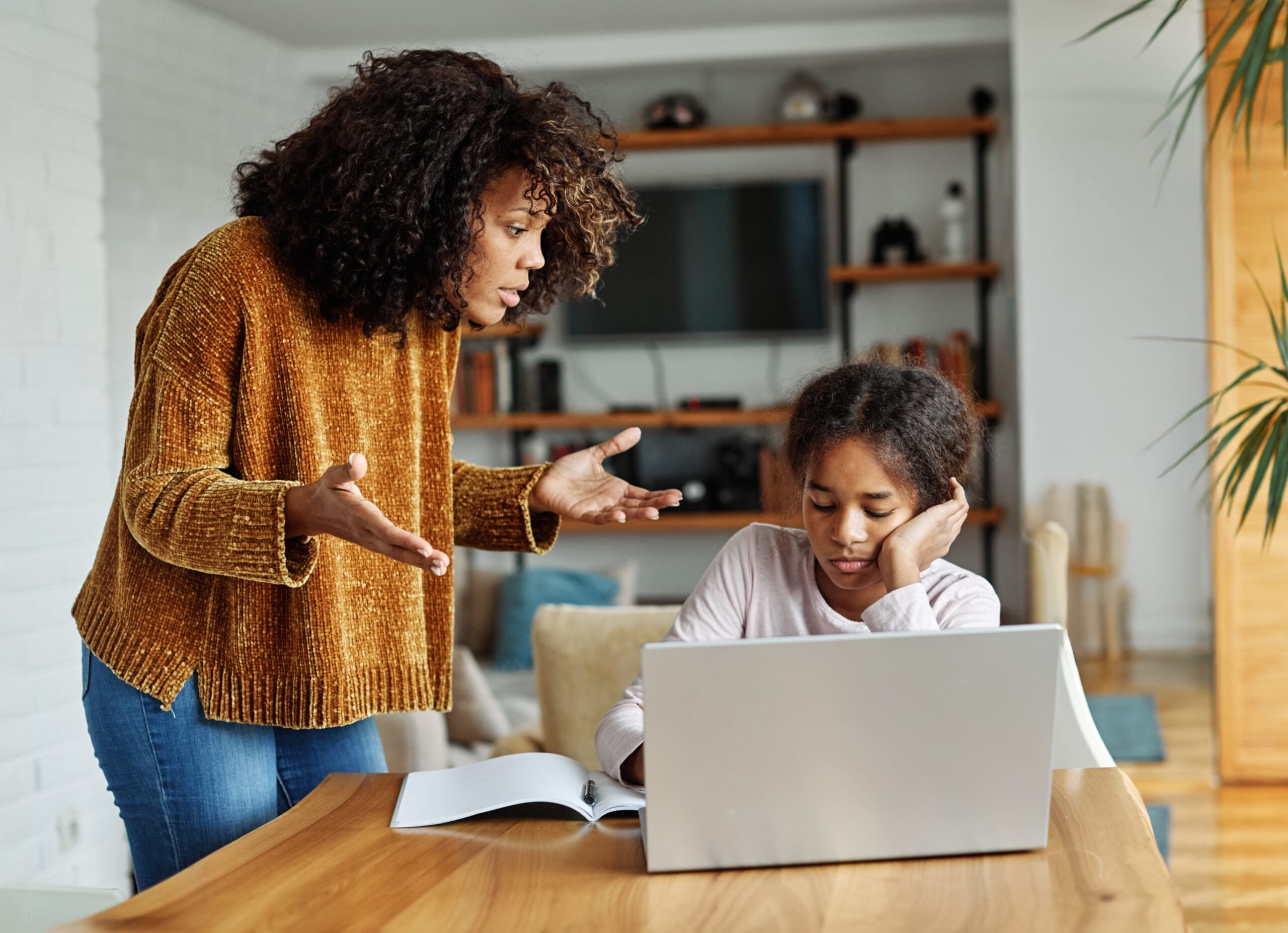 A mother scolding her daughter over her homework.