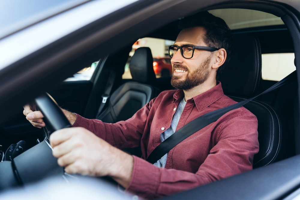 A smiling confident man driving to work