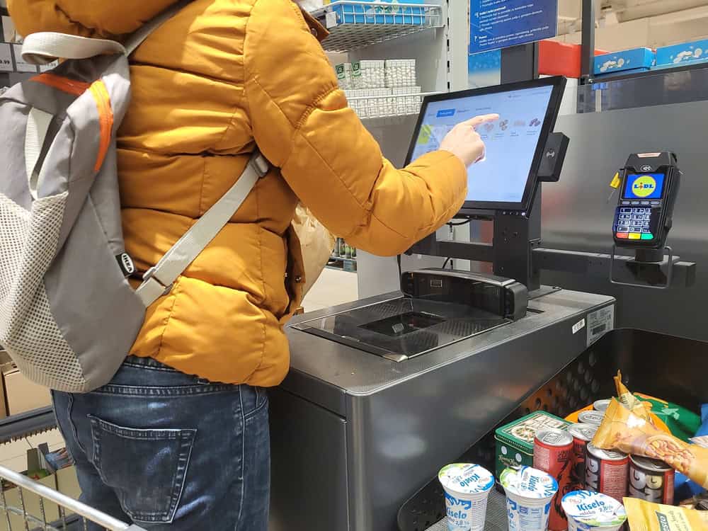 A woman at the self checkout at a supermarket