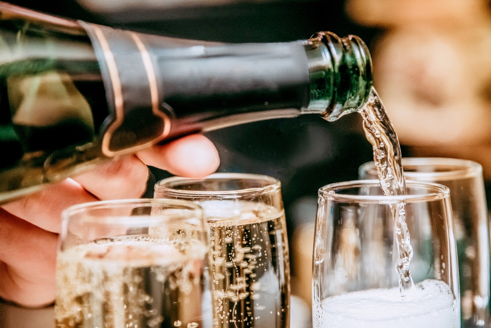 A waiter pouring fancy champagne in glasses.