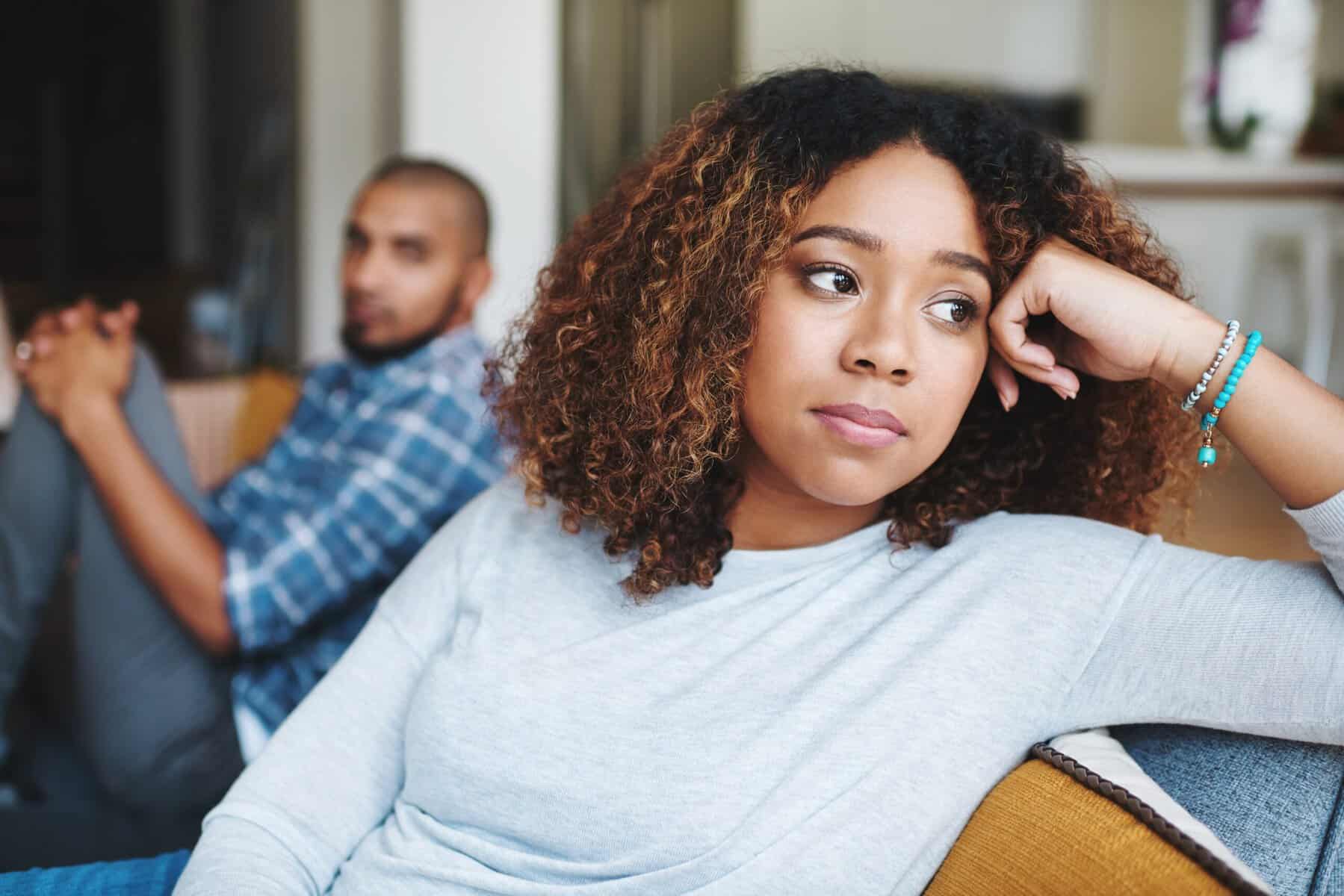 An emotionally unavailable woman looking away from her boyfriend during a disagreement.