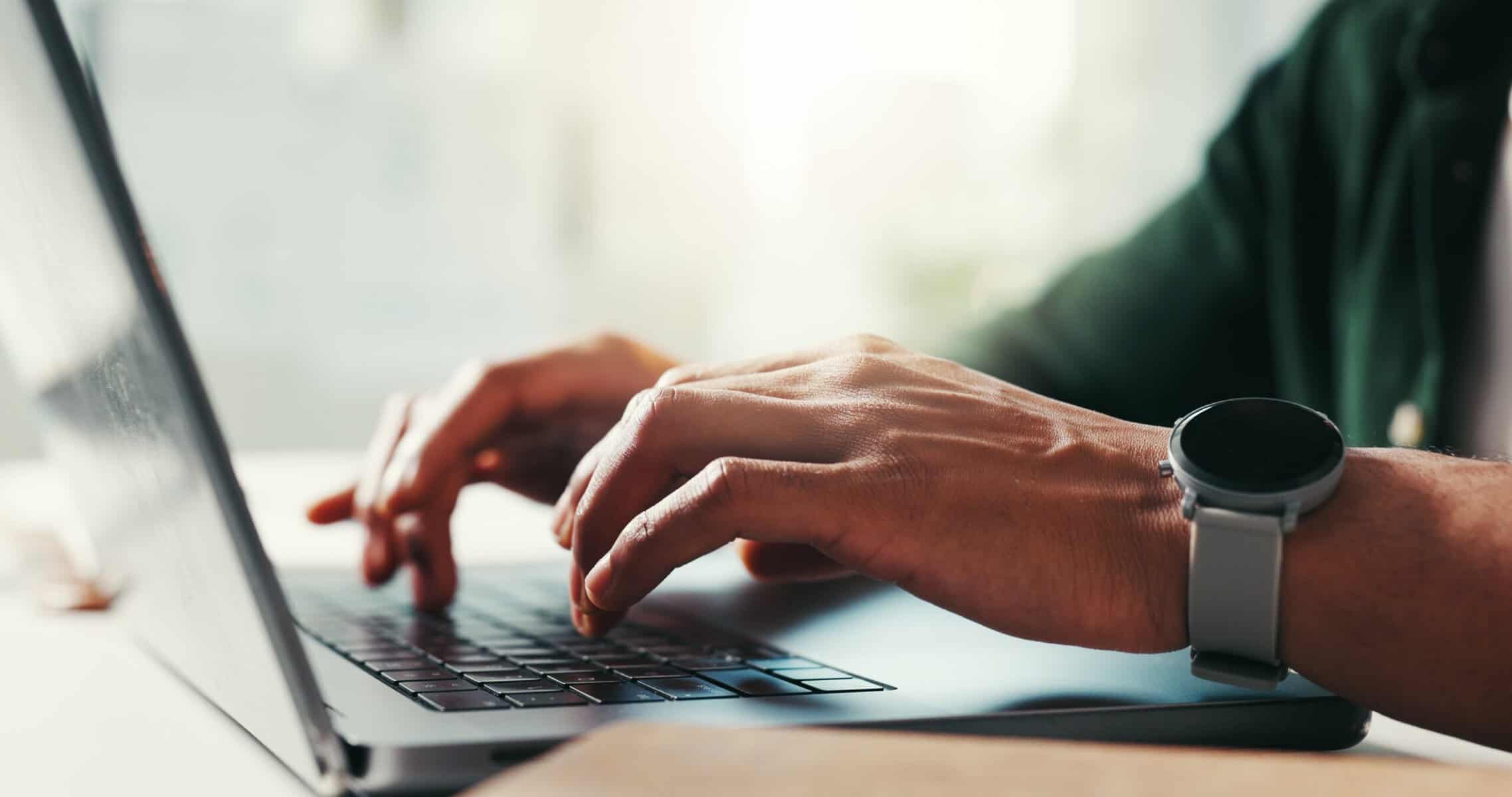 Hands of successful man typing on a laptop.