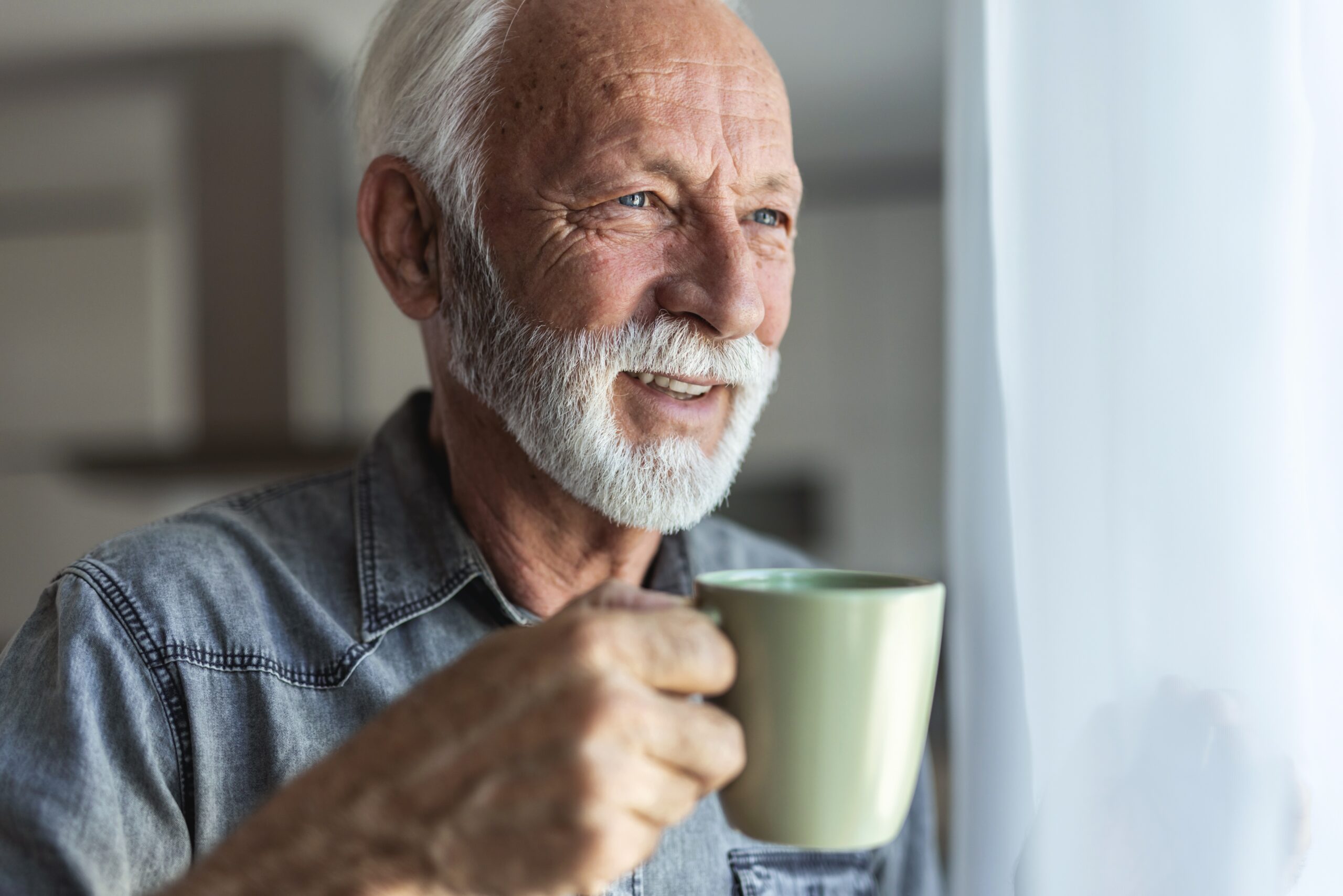 A happy mature man enjoying his morning coffee.