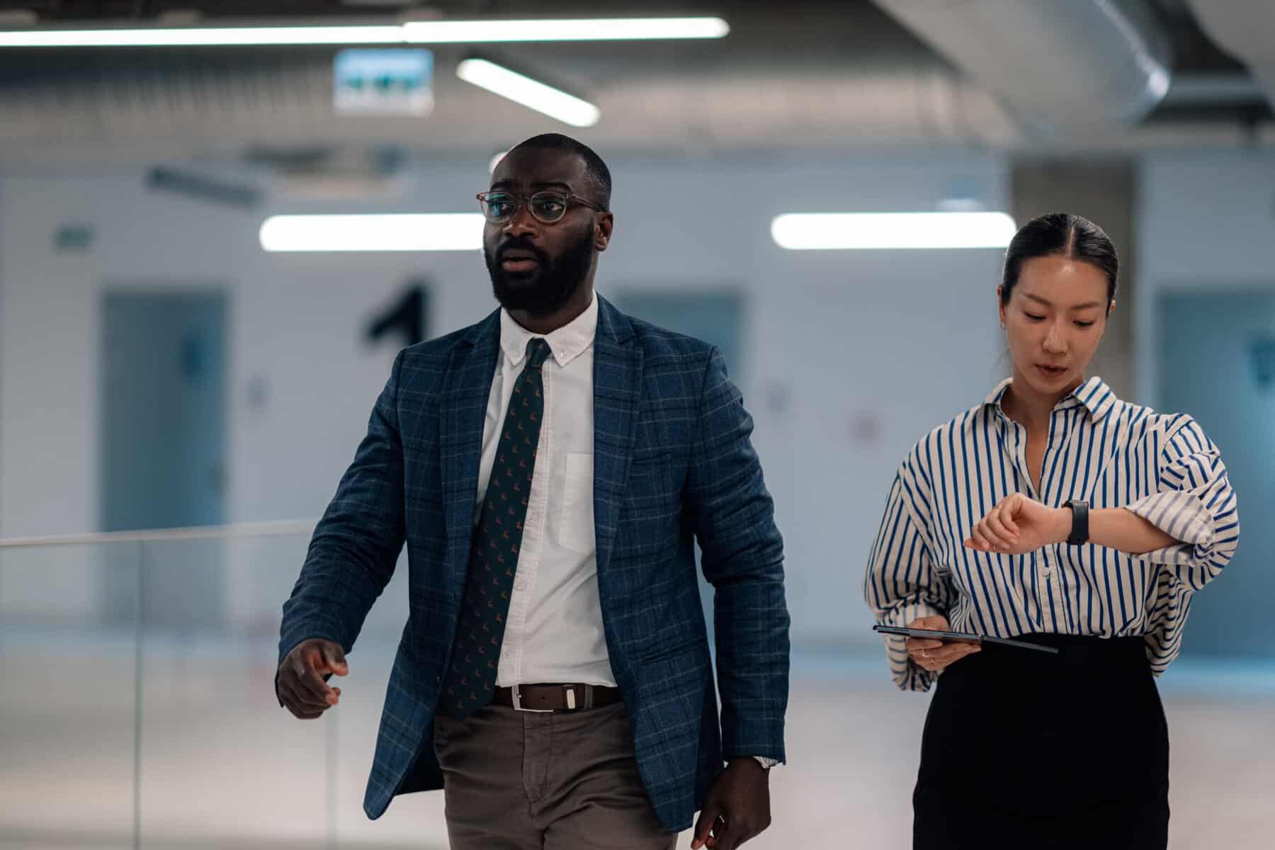 A punctual business man and business woman going to a meeting on time.