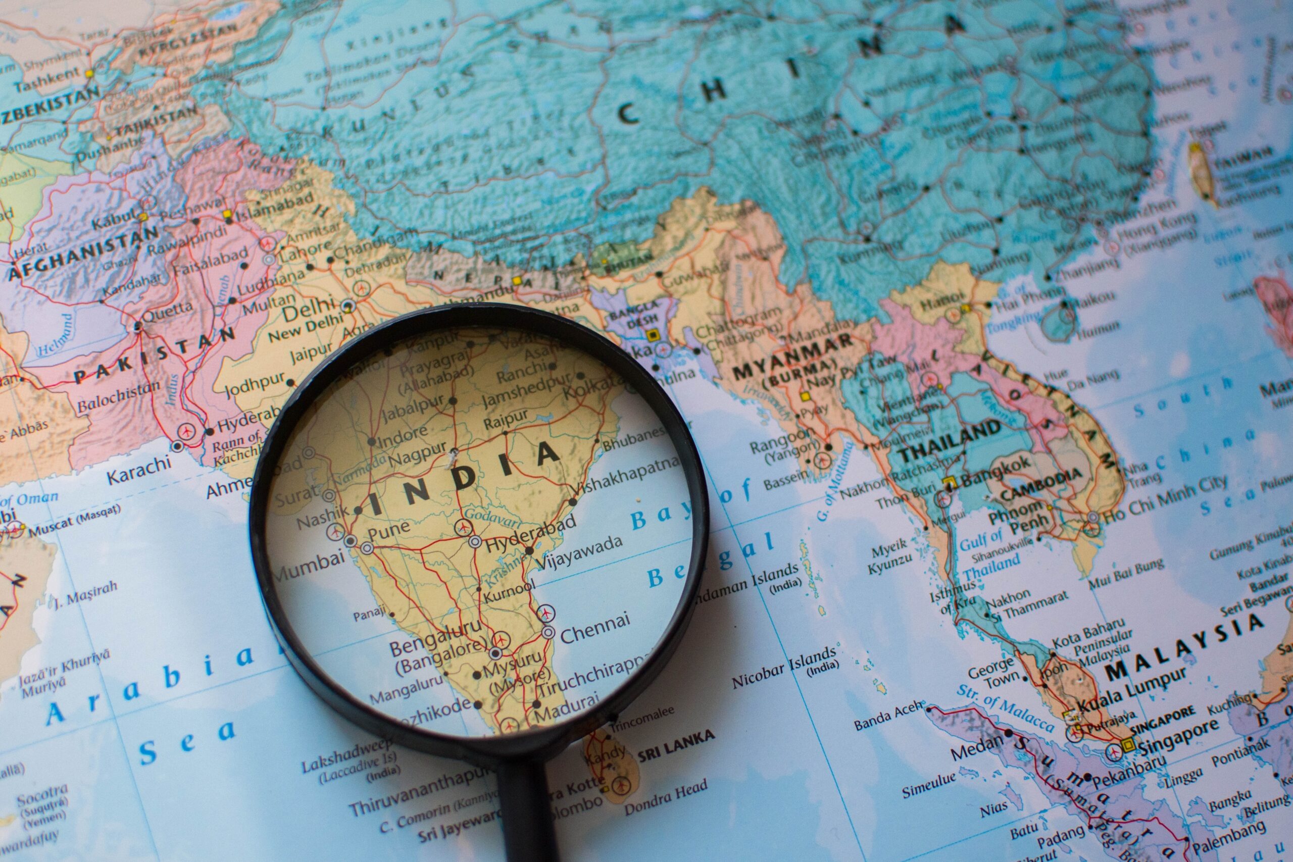A magnifying glass placed over a map of the world.