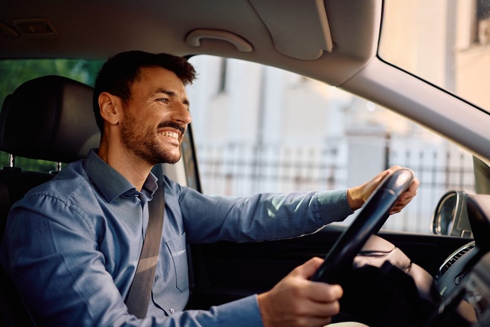 A smiling young man driving