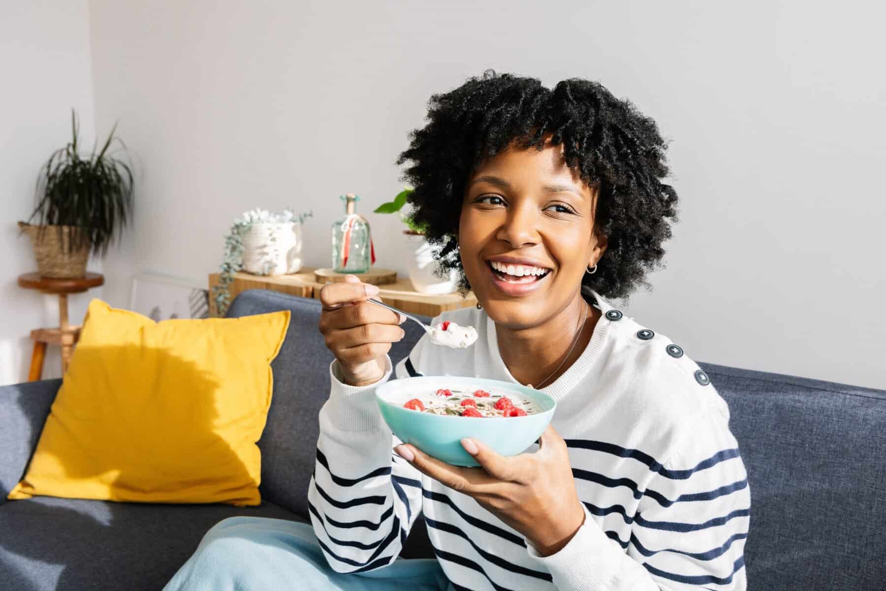 A woman having granola and fruit for breakfast.