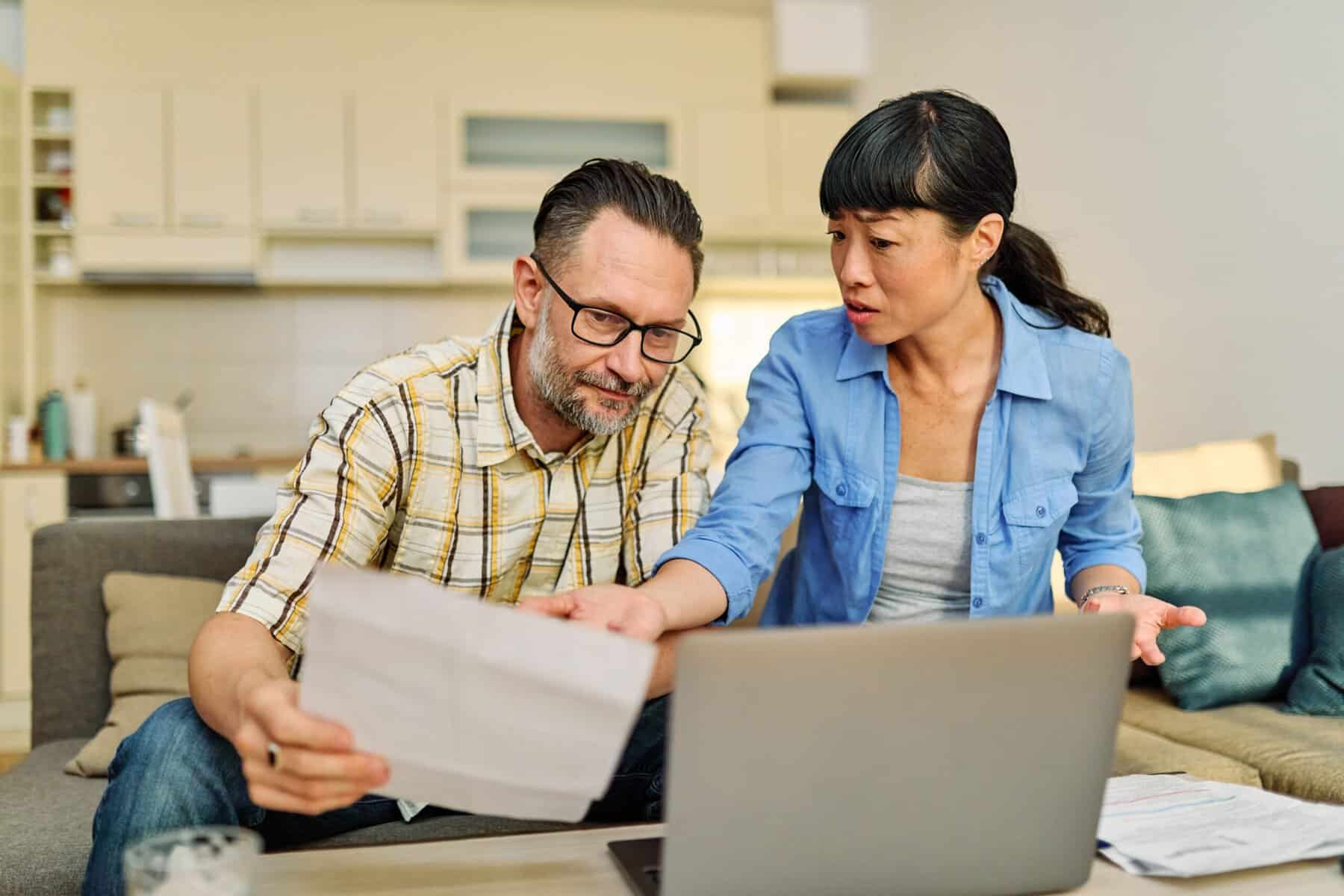 Married couple realizing they're having trouble paying the bills.